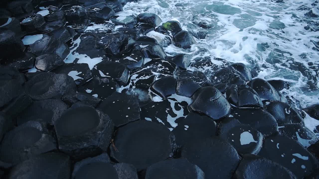 海浪冲击着北爱尔兰巨大堤道海岸线的六边形地质构造视频素材