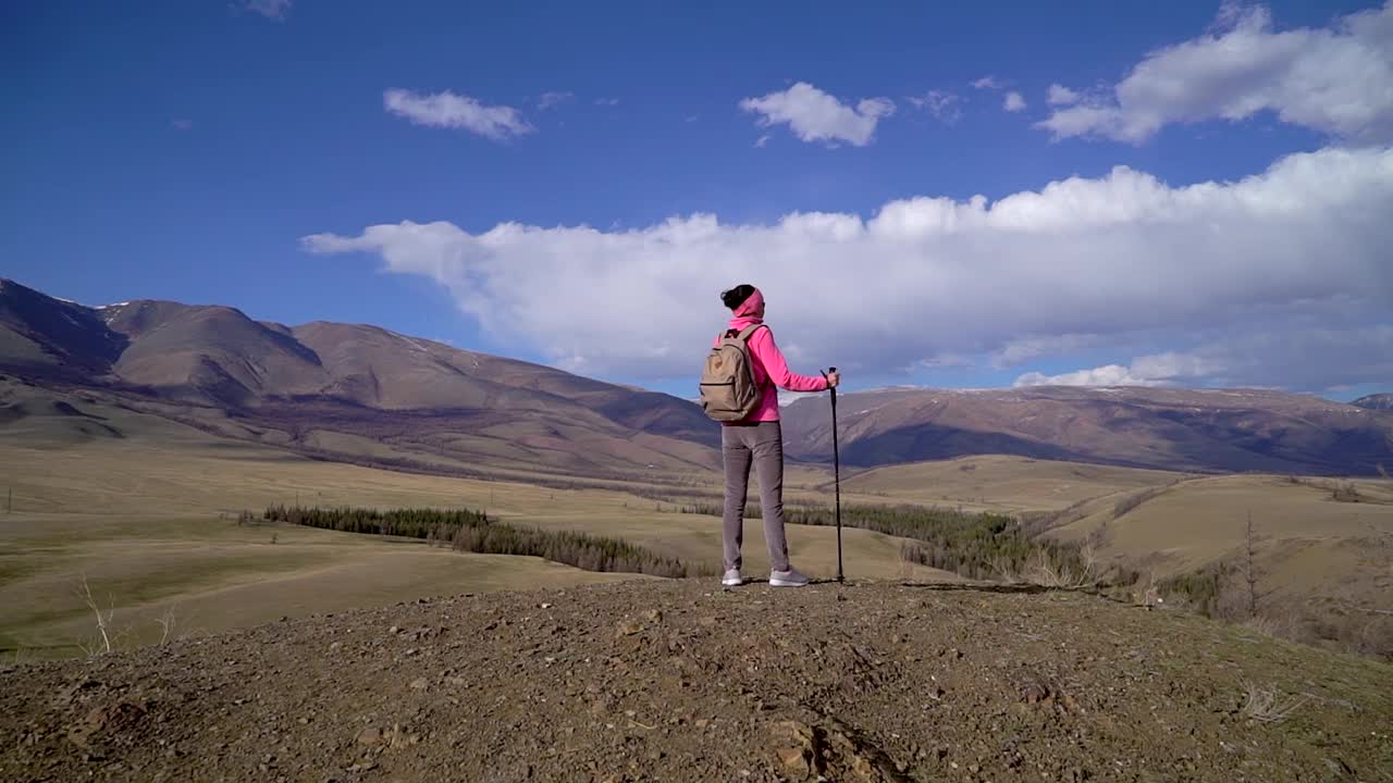 旅行家女子背包和徒步杆享受山顶视频素材