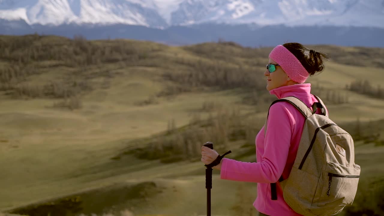 旅行家女子背包和徒步杆享受山顶视频素材