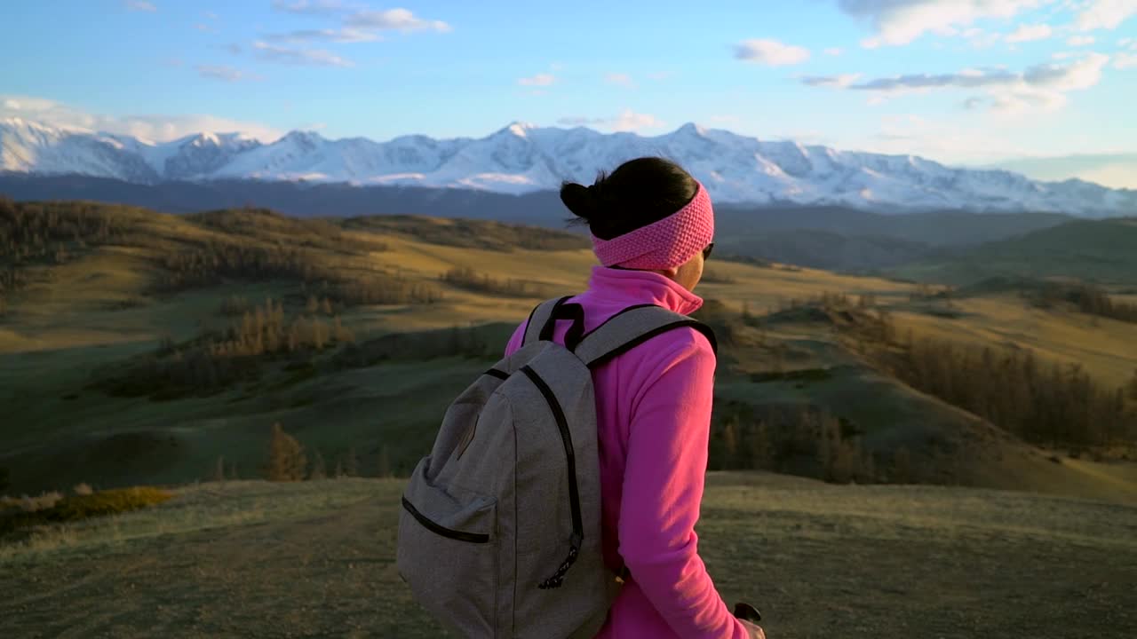 徒步旅行者女子背着背包，拄着拐杖徒步爬上山顶视频素材