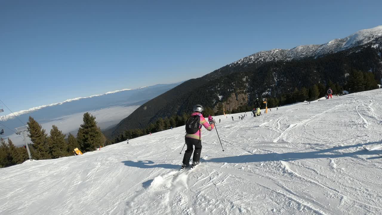 年轻的女孩在高海拔的斜坡上做冬季运动滑雪视频素材