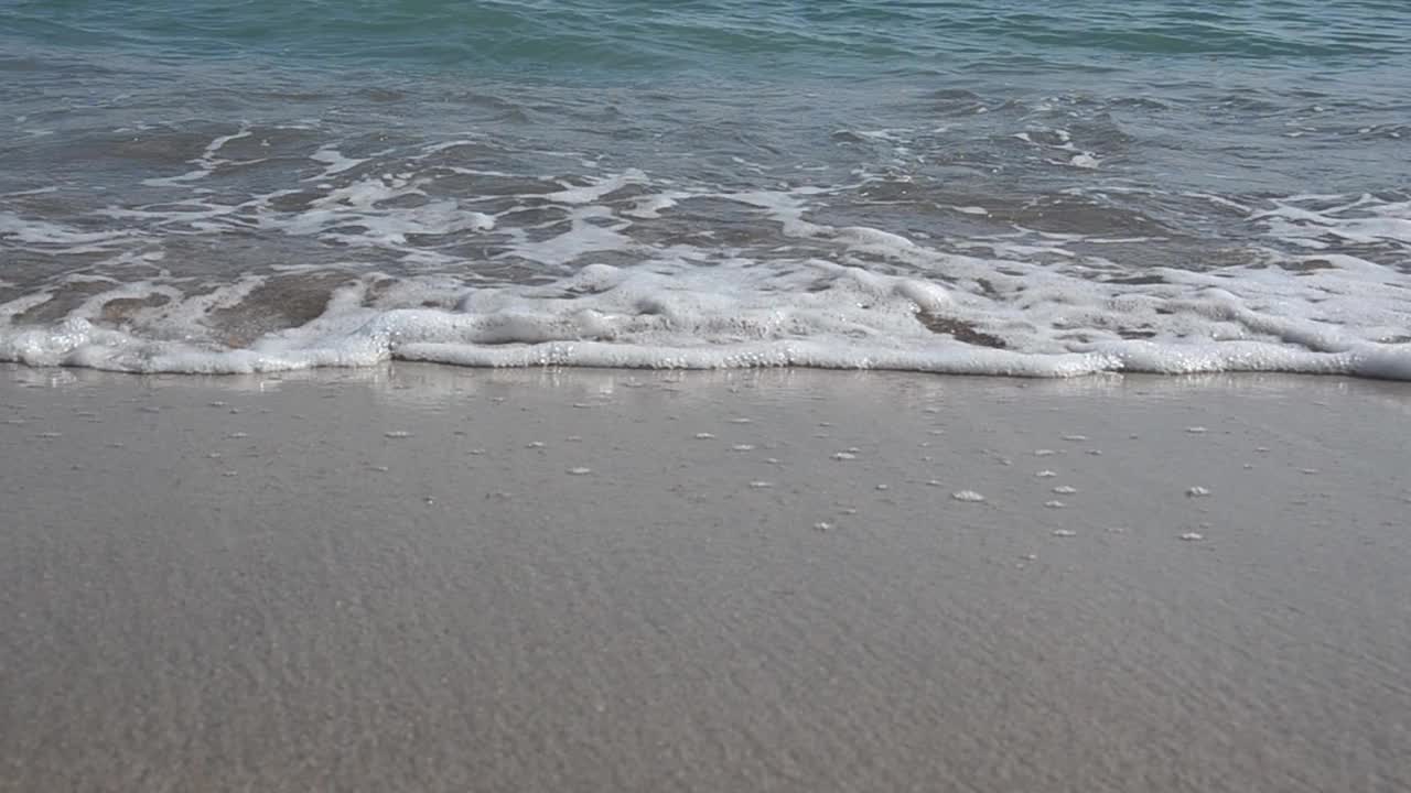 美丽和平静的观点，海浪拍打在沙滩上在一个夏天的一天在高清视频素材