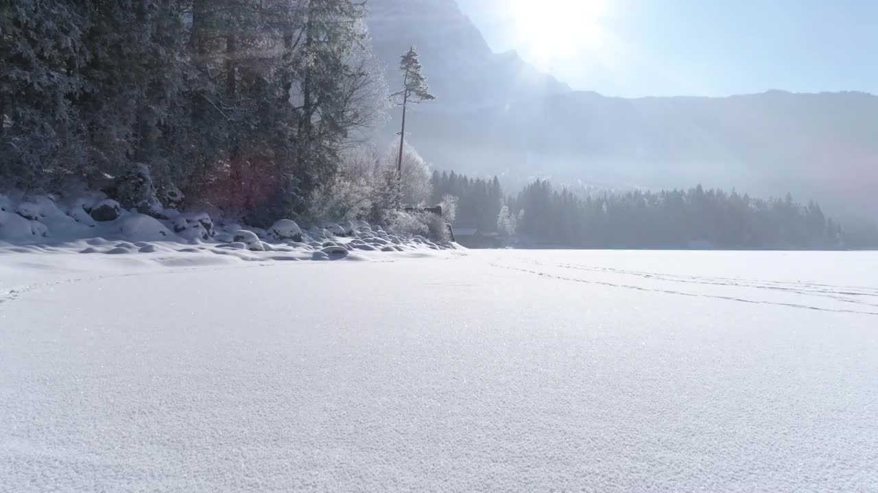 在德国巴伐利亚州冰雪覆盖的湖面上飞行视频素材