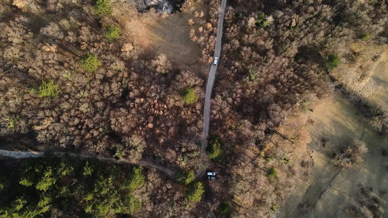 鸟瞰图上的汽车行驶在碎石路上在农村的场景视频素材