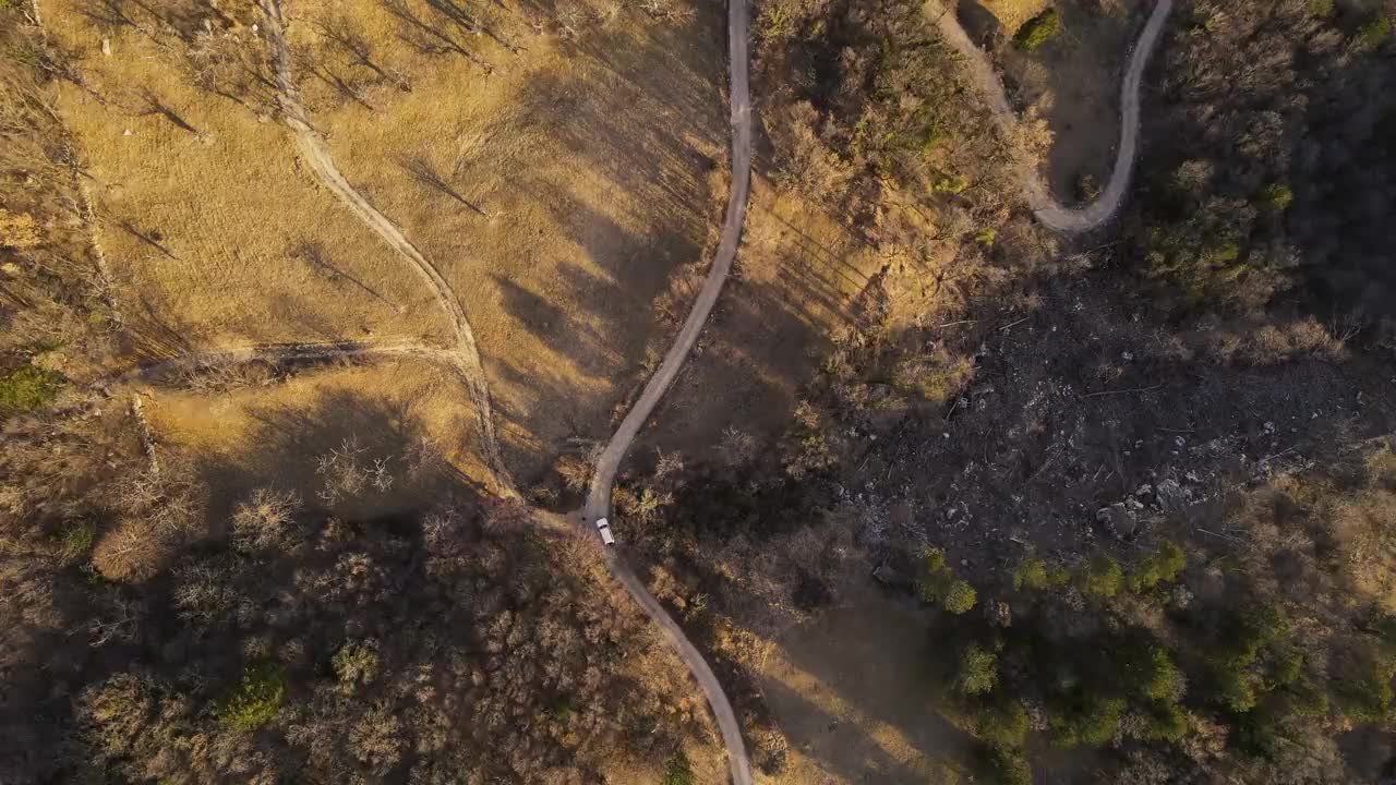 鸟瞰一辆行驶在乡村蜿蜒道路上的汽车视频素材