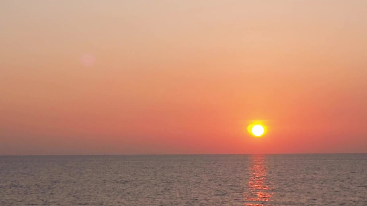 海边的日落。粉橙紫的天空在夜晚的海上。在平静的海浪中缓缓落水。美化宁静的风景自然镜头。海和海滩旅行b卷视频背景。视频素材