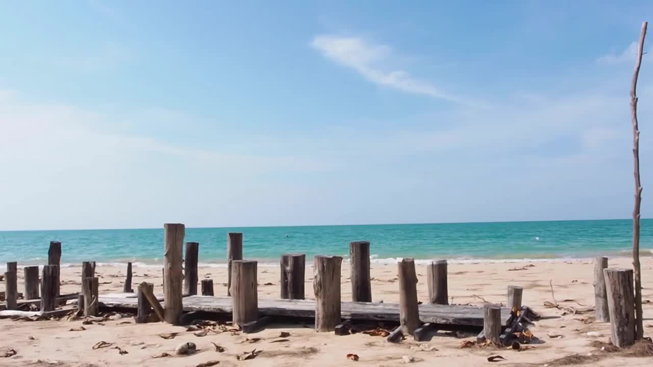 美丽的大海和沙滩，蓝天白云，夏日阳光明媚，热带岛屿的沙滩上有一座古老的木桥，私人旅行在一个广阔的空间背景。b卷录像视频素材