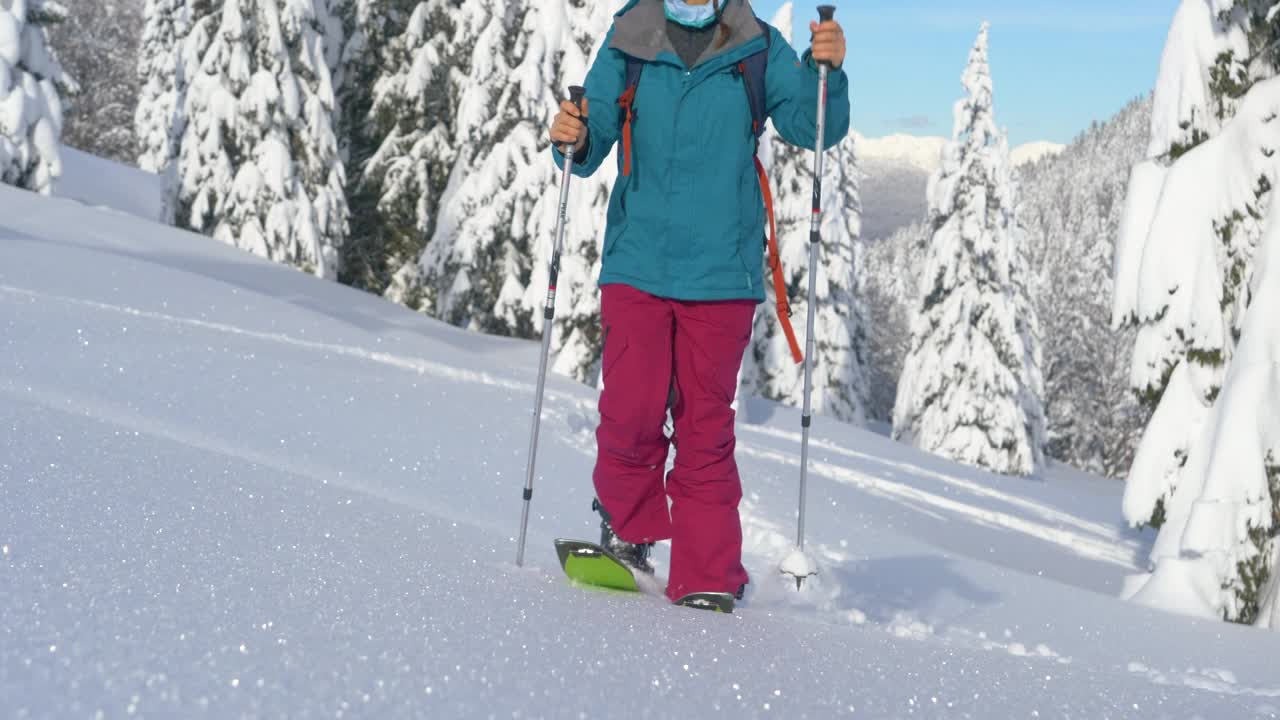 低角度:无法辨认的女性分裂者爬上了一个闪闪发光的雪原视频素材