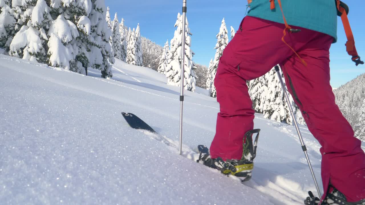 近距离观察:健康女性在朱利安阿尔卑斯山滑雪旅行时，在深雪中远足。视频素材