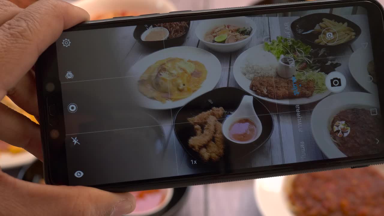 俯视图男子用智能手机拍摄餐盘上的食物视频素材