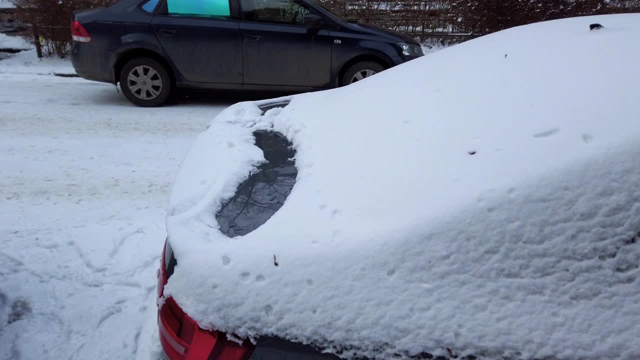 汽车在城市的街道上被雪覆盖着。视频素材