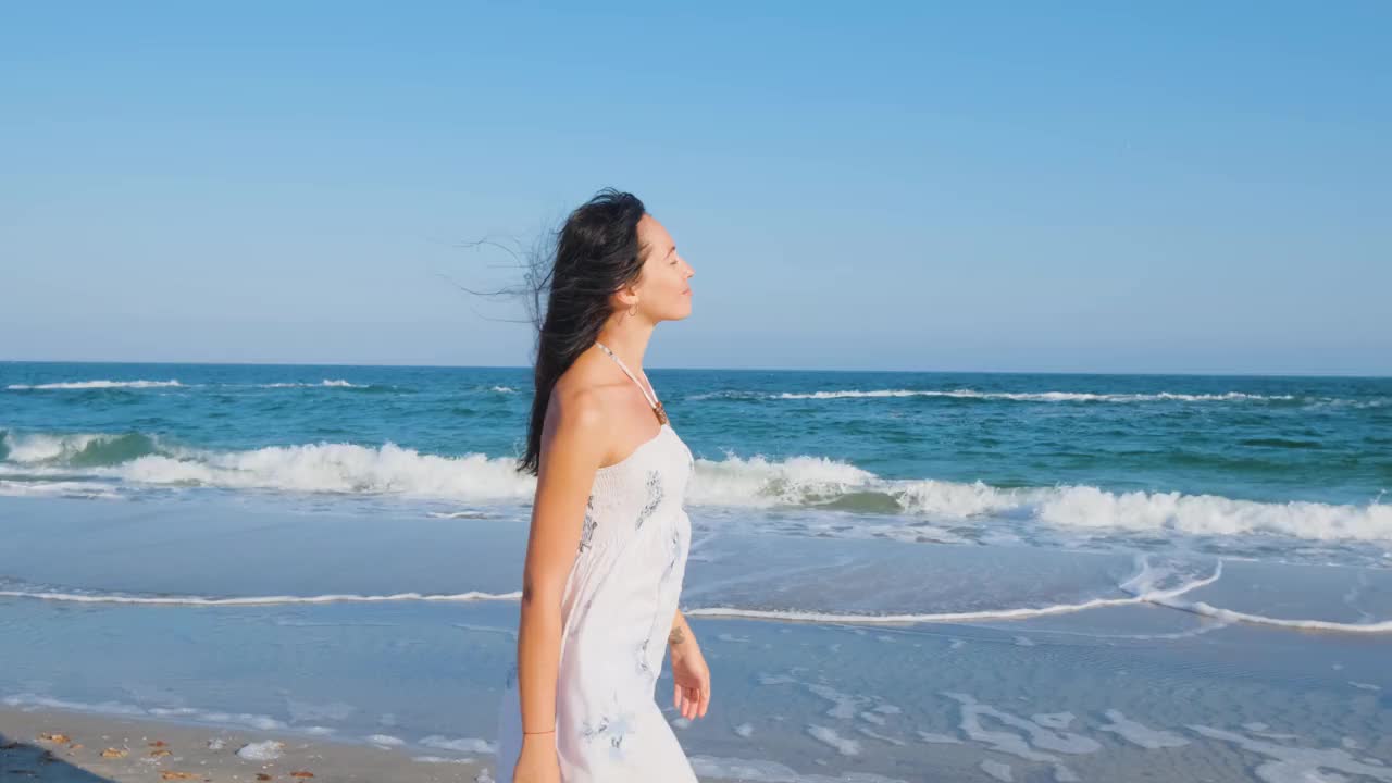 在夏日海滩上行走的女性视频素材