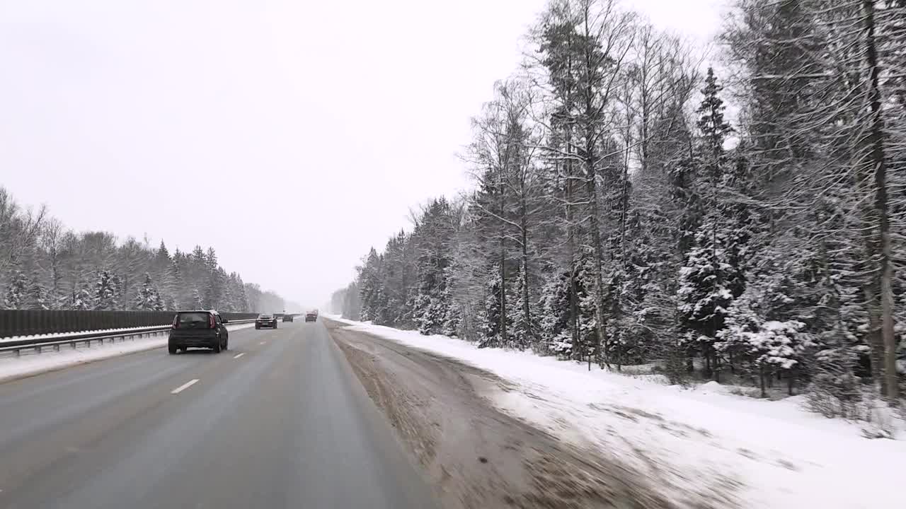 俄罗斯。冬天下雪的雅罗斯拉夫尔高速公路上，透过挡风玻璃观看汽车视频素材