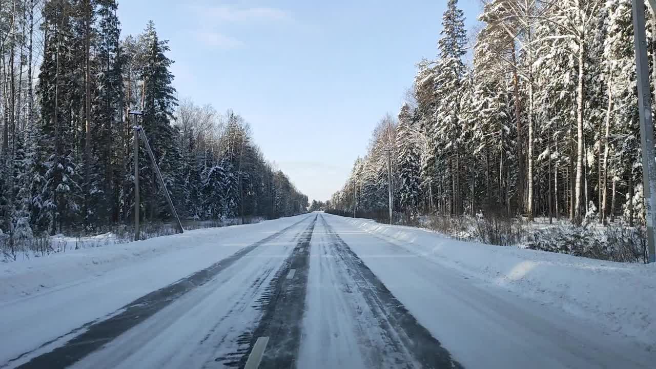 透过挡风玻璃，一辆汽车在森林中一条滑的道路上行驶视频素材