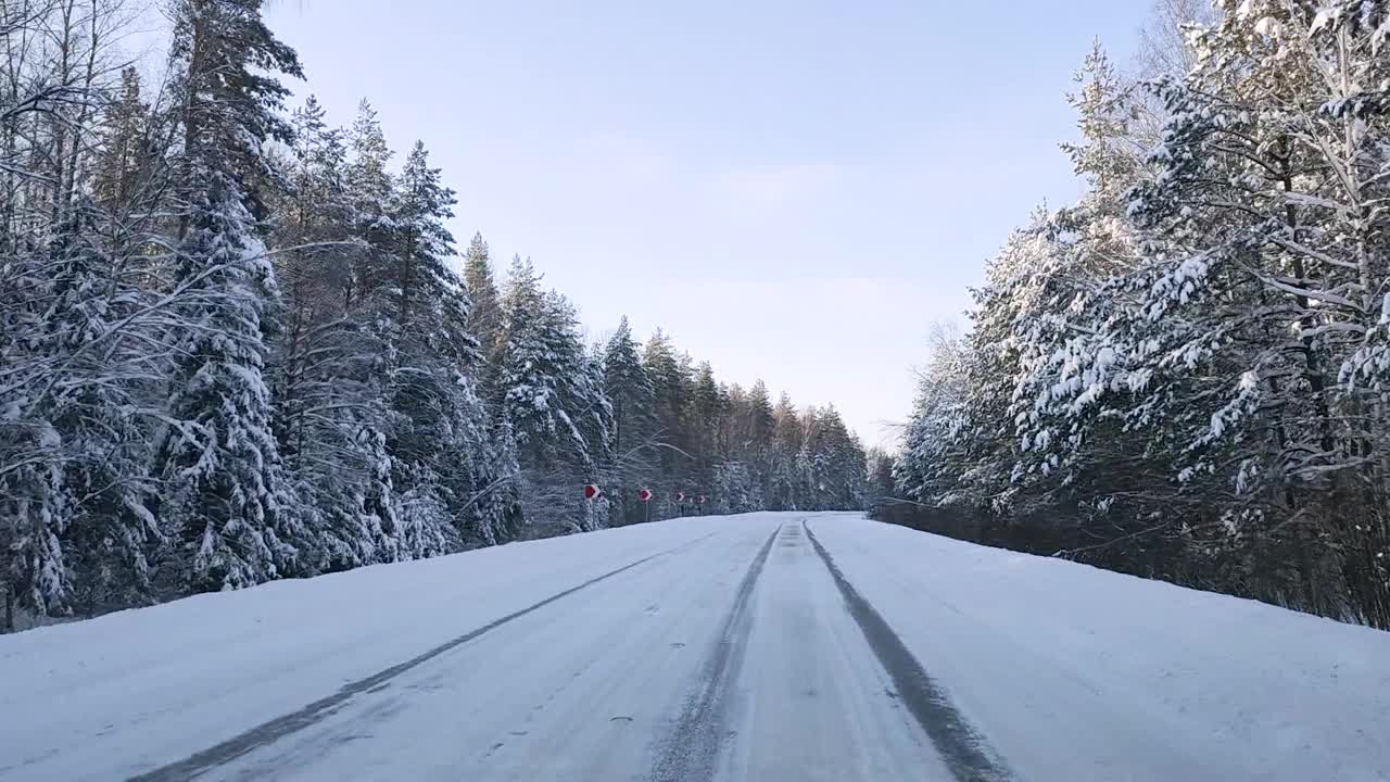 透过挡风玻璃，一辆汽车在森林中湿滑的道路上转弯视频素材