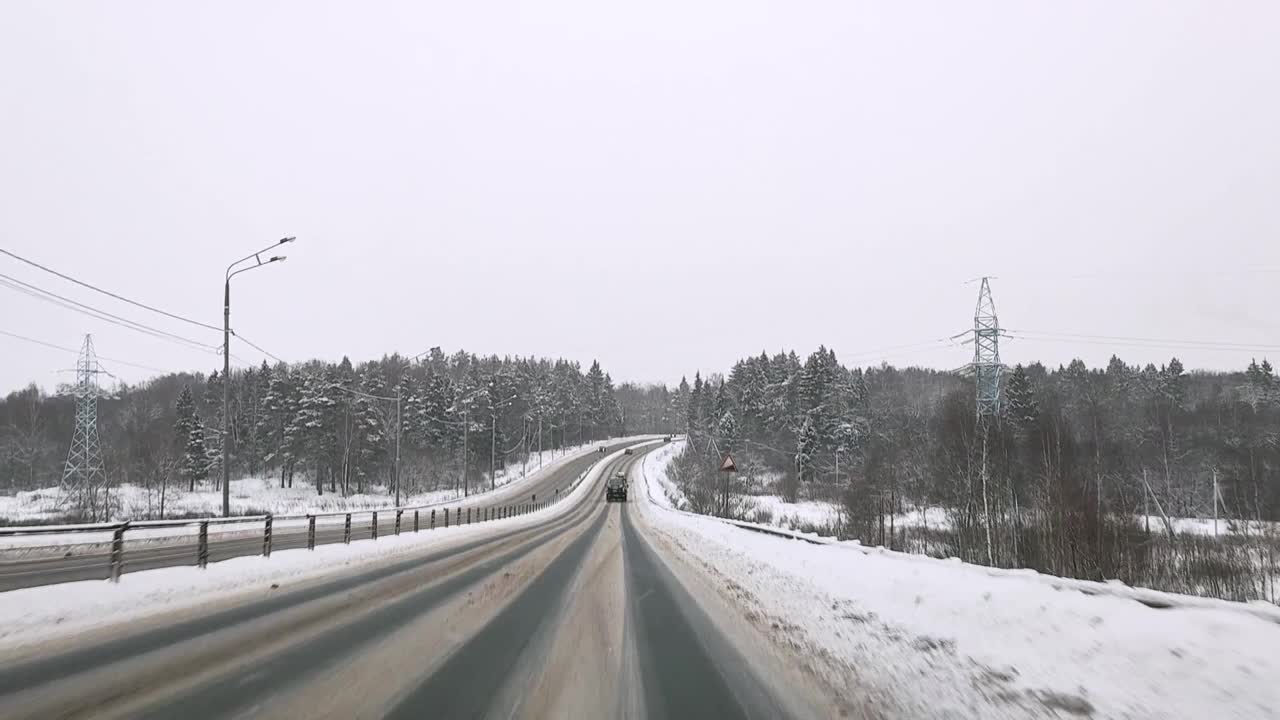 俄罗斯。冬天下雪的雅罗斯拉夫尔高速公路上，透过挡风玻璃观看汽车视频素材