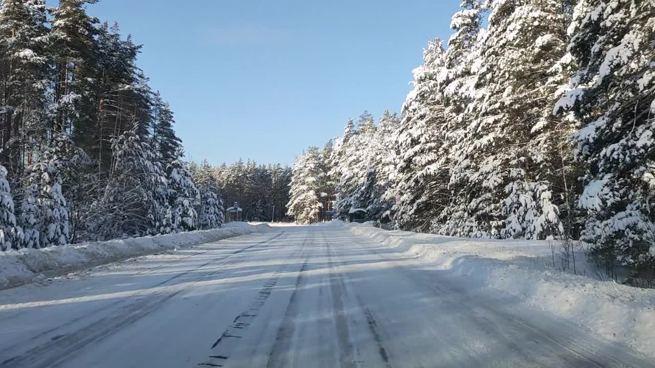 透过挡风玻璃，一辆汽车在森林中一条滑的道路上行驶视频素材