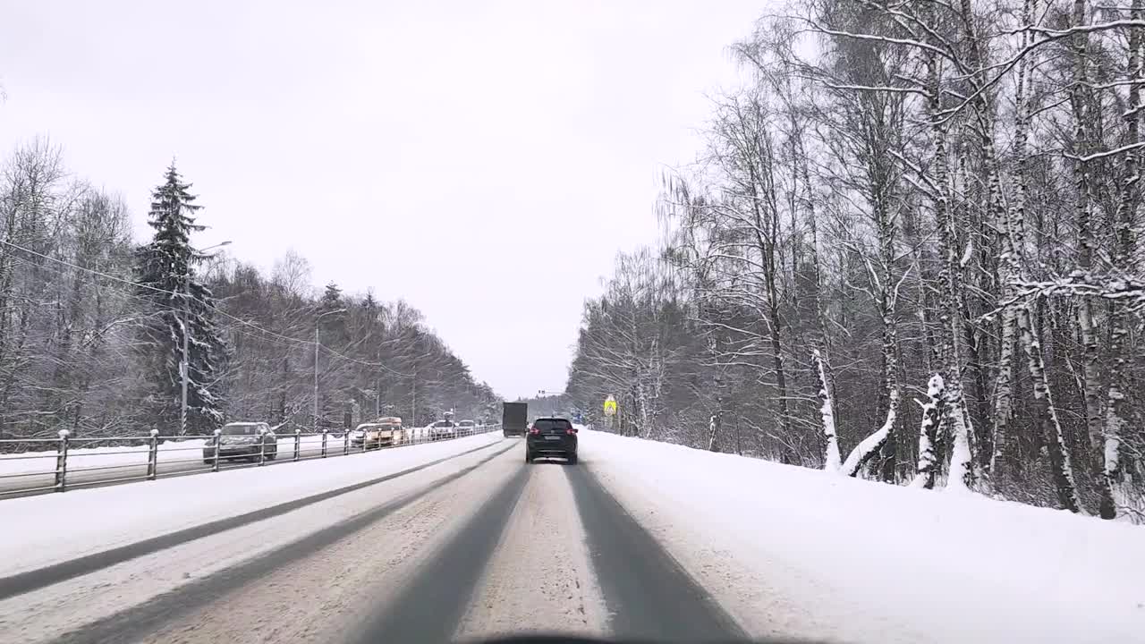 俄罗斯。冬天下雪的雅罗斯拉夫尔高速公路上，透过挡风玻璃观看汽车视频素材