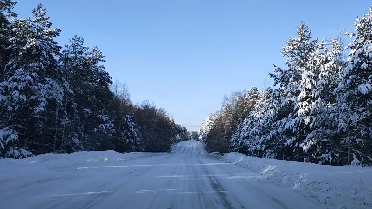 透过挡风玻璃，一辆汽车正在森林里滑的道路上上坡行驶视频素材