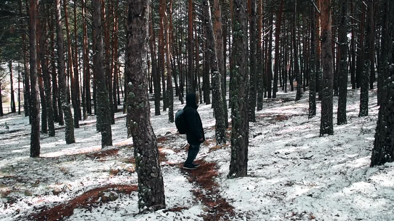 下雪时，一个穿外套的年轻人抬起头来视频素材