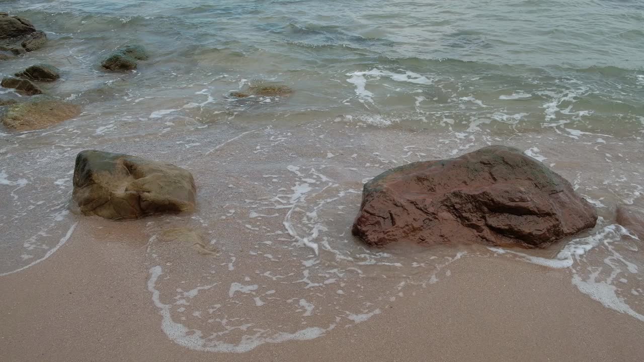 海滩上有许多岩石。而且总是被海浪袭击。视频素材