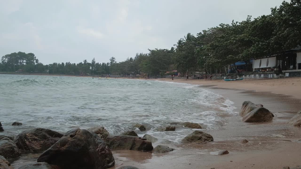 在有许多岩石的海滩上，海浪不停地拍打着海岸。视频素材