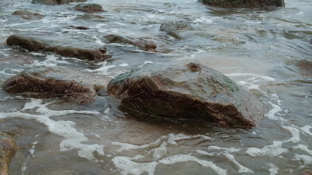 海滩上有许多岩石。而且总是被海浪袭击。视频素材