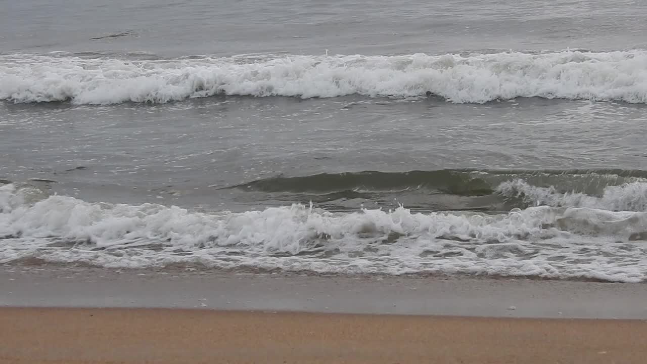 多云的海滩和巨浪袭击海岸。多云的海洋和平静的海滩景观。惊人的平静的海滩。早晨乌云密布的海滩上乌云密布。海面上的小波浪日落。金色的夕阳和黄色的阳光。视频素材