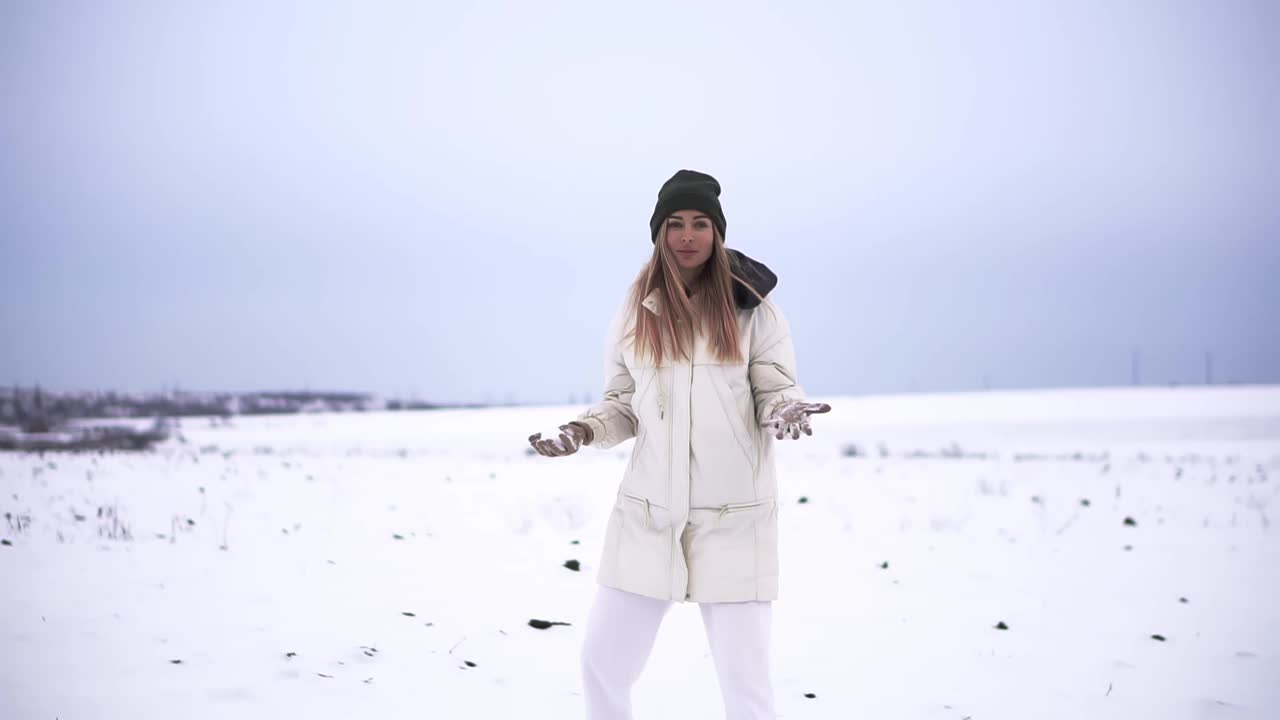 女孩朝镜头扔雪球，开心地在户外玩视频素材