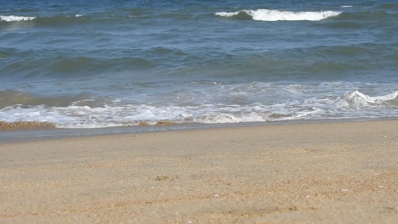 在风景的蓝色海滩，田园诗海岸海滩与绿松石水。浪花在白色的沙滩上拍打。海浪拍打着美丽的海滩视频素材