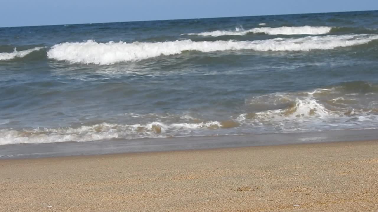 在风景的蓝色海滩，田园诗海岸海滩与绿松石水。浪花在白色的沙滩上拍打。海浪拍打着美丽的海滩视频素材