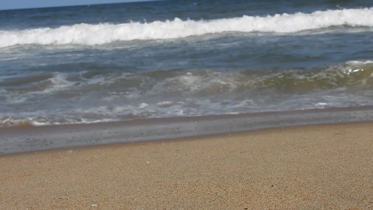 在风景的蓝色海滩，田园诗海岸海滩与绿松石水。浪花在白色的沙滩上拍打。海浪拍打着美丽的海滩视频素材