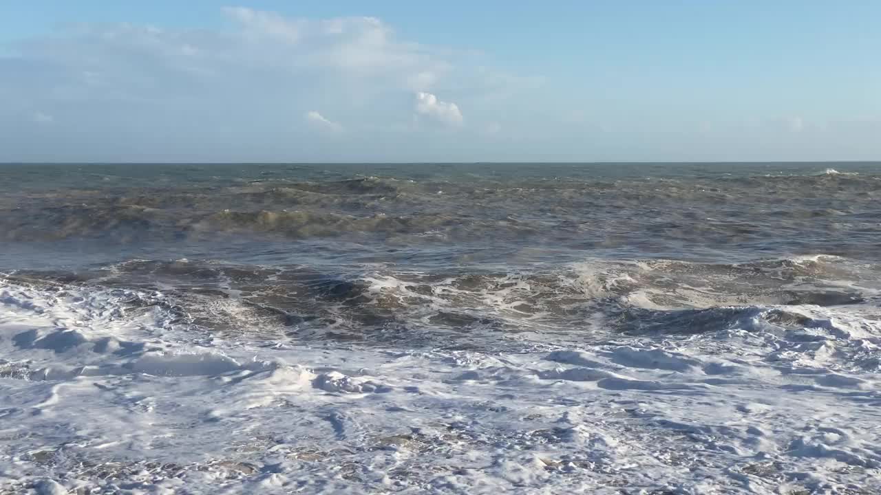 视频非常波涛汹涌的大海和波浪在阳光和多云的天气。视频素材