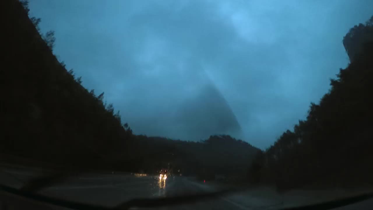 在雨天的山路上旅行，时间流逝视频从车内。视频素材