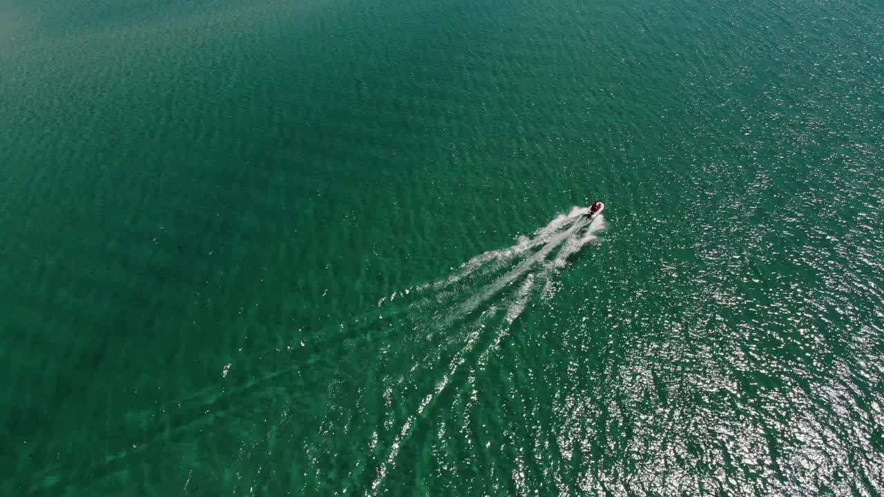 海湾中一艘小型快艇的鸟瞰图。轻型水上运输俯视图。令人惊叹的热带海湾的绿松石水视频素材