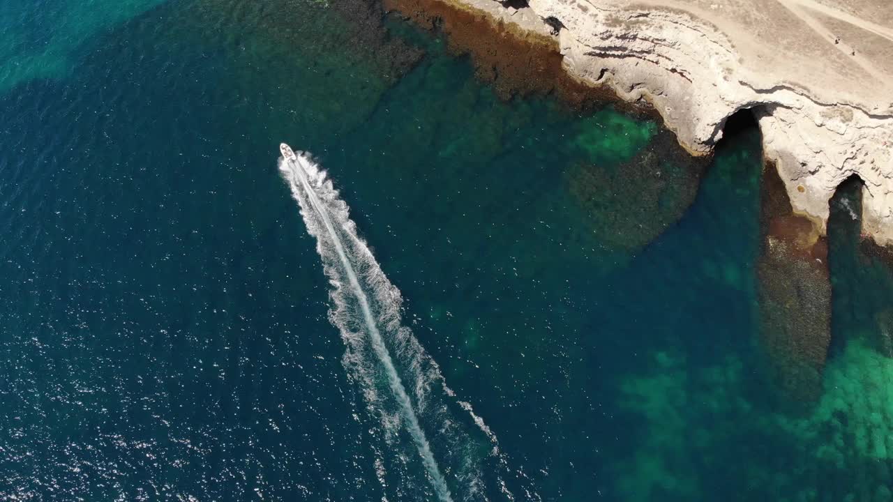 海湾中一艘小型快艇的鸟瞰图。轻型水上运输俯视图。令人惊叹的热带海湾的绿松石水视频素材