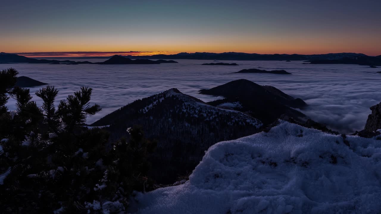 美丽的冬季日出在野生雪山景观与低雾云在山谷自然时间流逝多莉拍摄视频素材