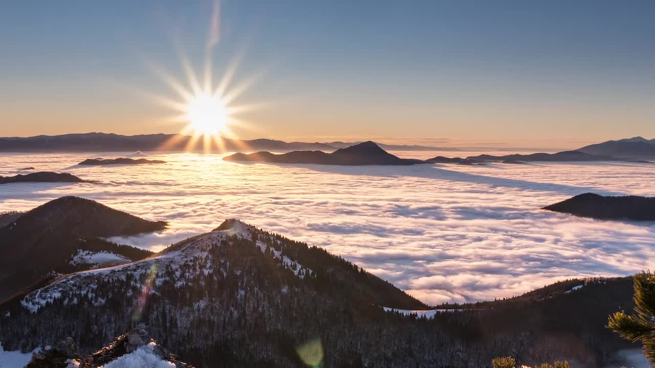 缤纷的日落在冬季山地景观时间流逝与低云在雾森林和平的自然风景视频素材