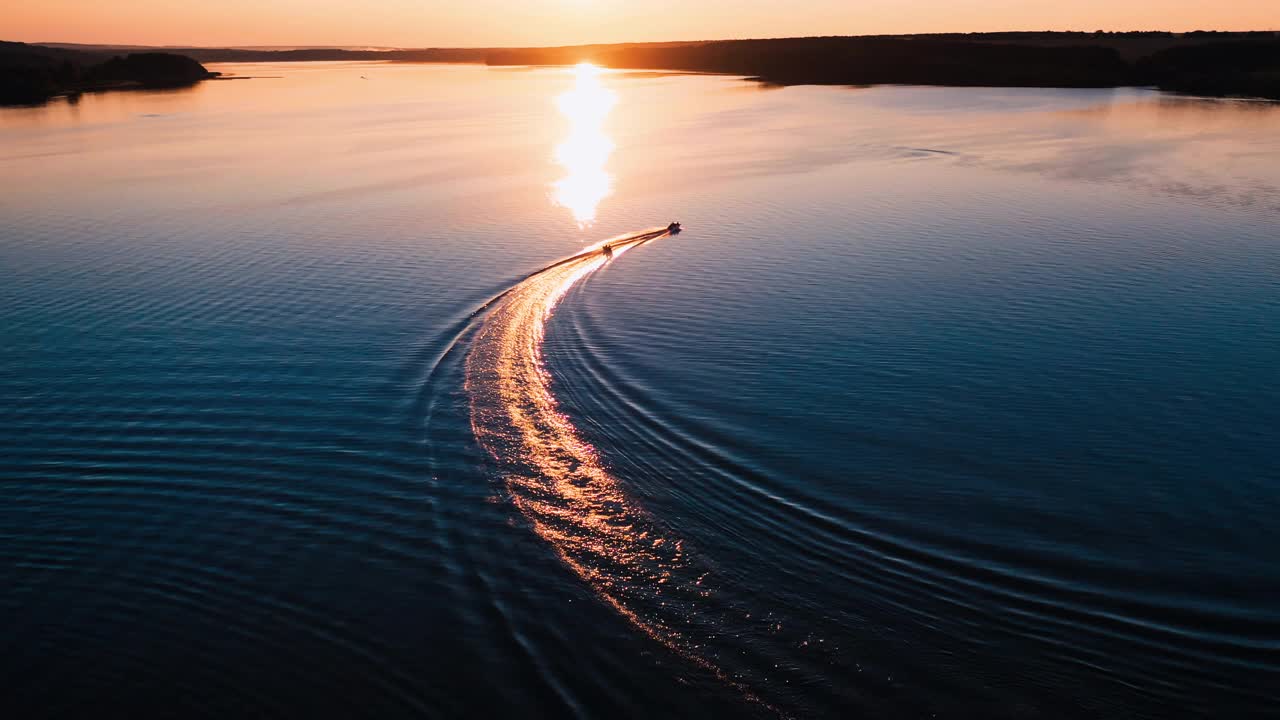 日落时分，美丽的河上的小船。在夕阳的照耀下，小船在金色的小路上移动。鸟瞰图。视频素材