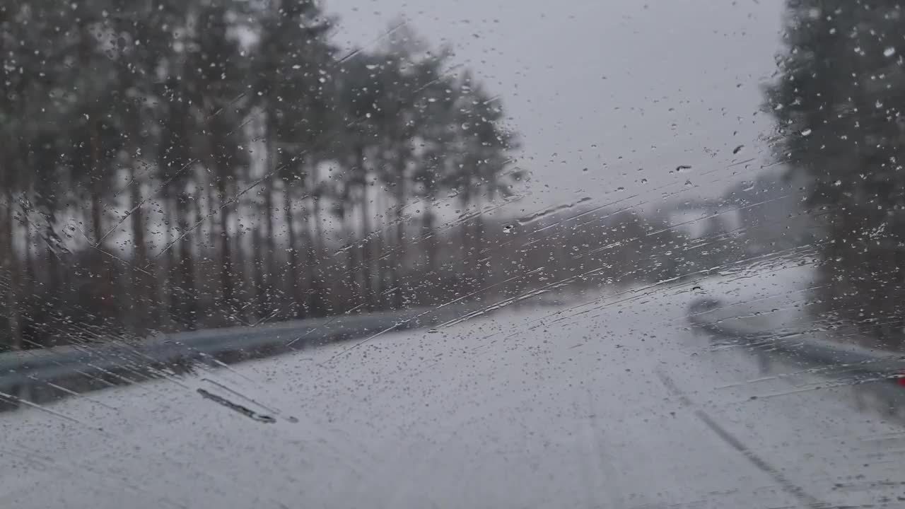 从机舱内看冬天，汽车刮水器会清理挡风玻璃上的积雪。危险的天气状况，道路安全。视频素材