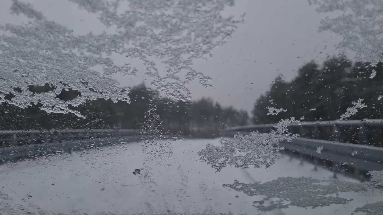 从机舱内看冬天，汽车刮水器会清理挡风玻璃上的积雪。危险的天气状况，道路安全。视频下载