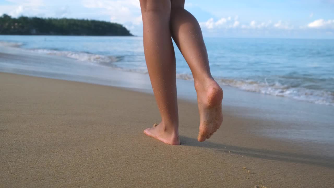 海滩旅行-女人赤脚走在海滩海岸线留下脚印在沙子上视频素材