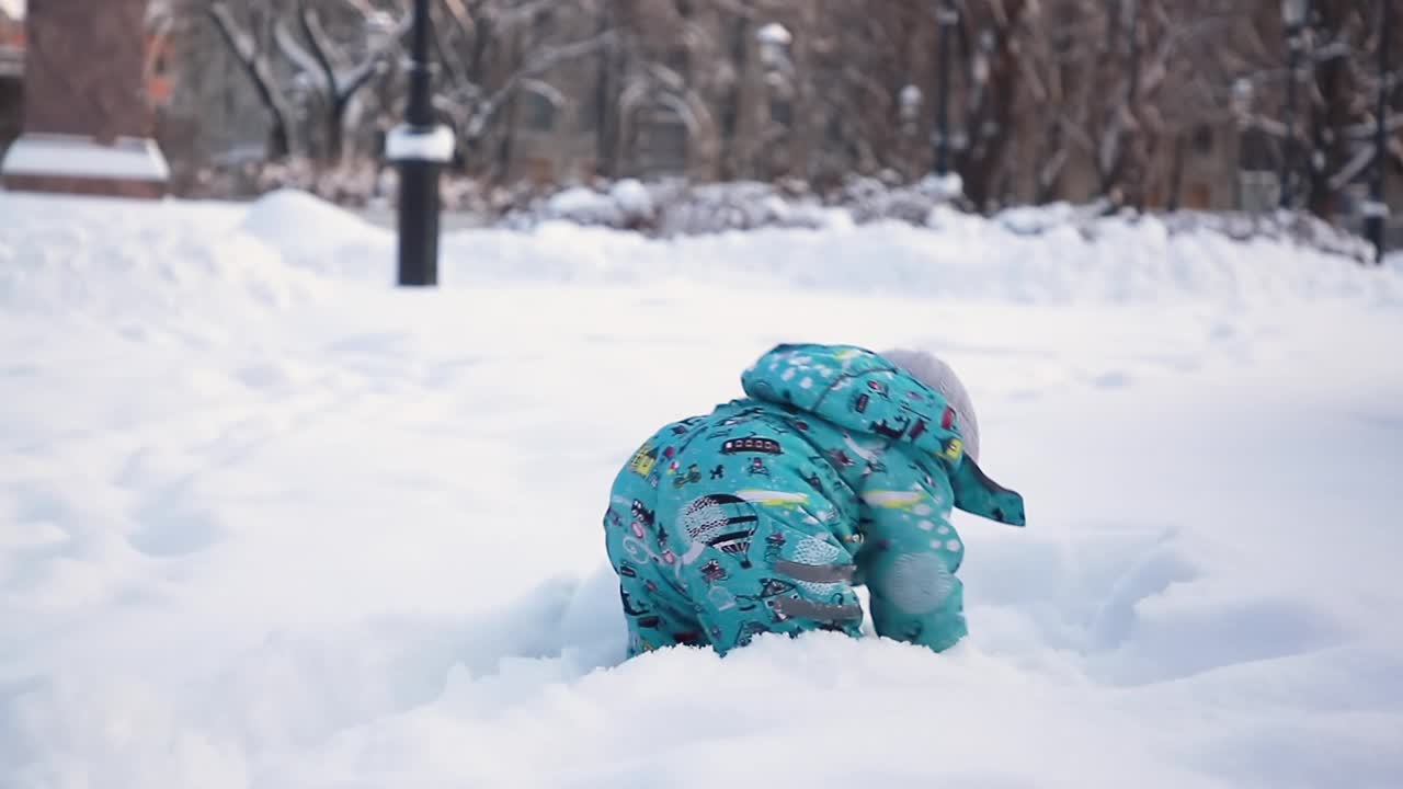 可爱的男孩在冬天的雪地里玩耍。视频素材