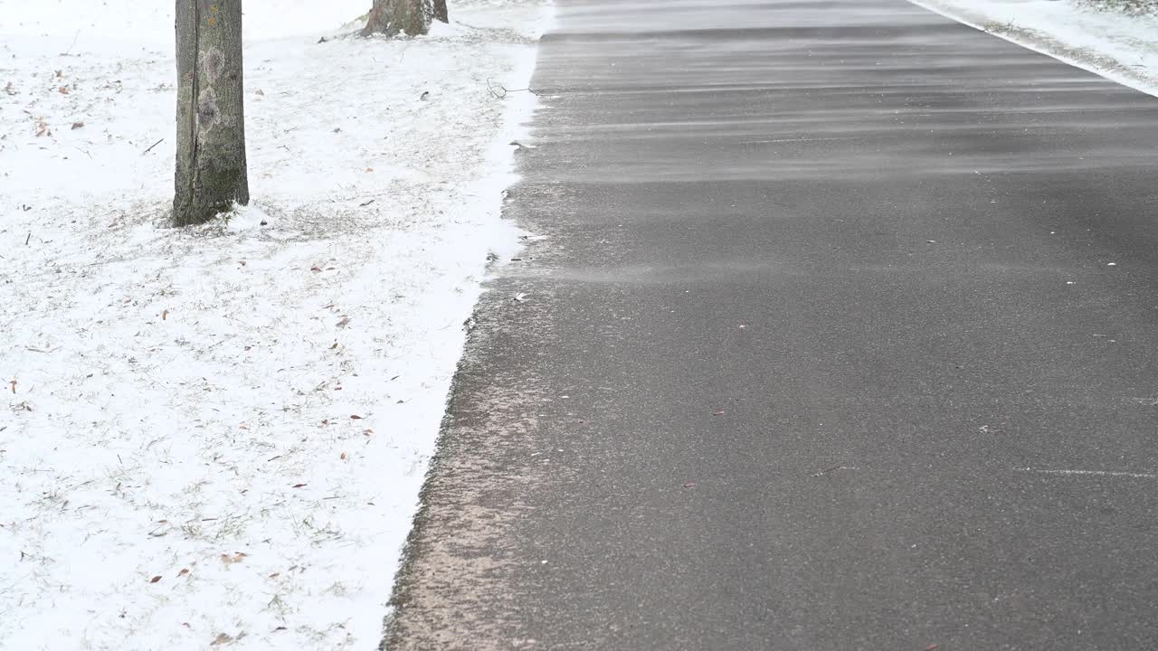 飓风风吹起粉末雪，铺在乡间小路的柏油路面上。Bandenburg。德国视频素材