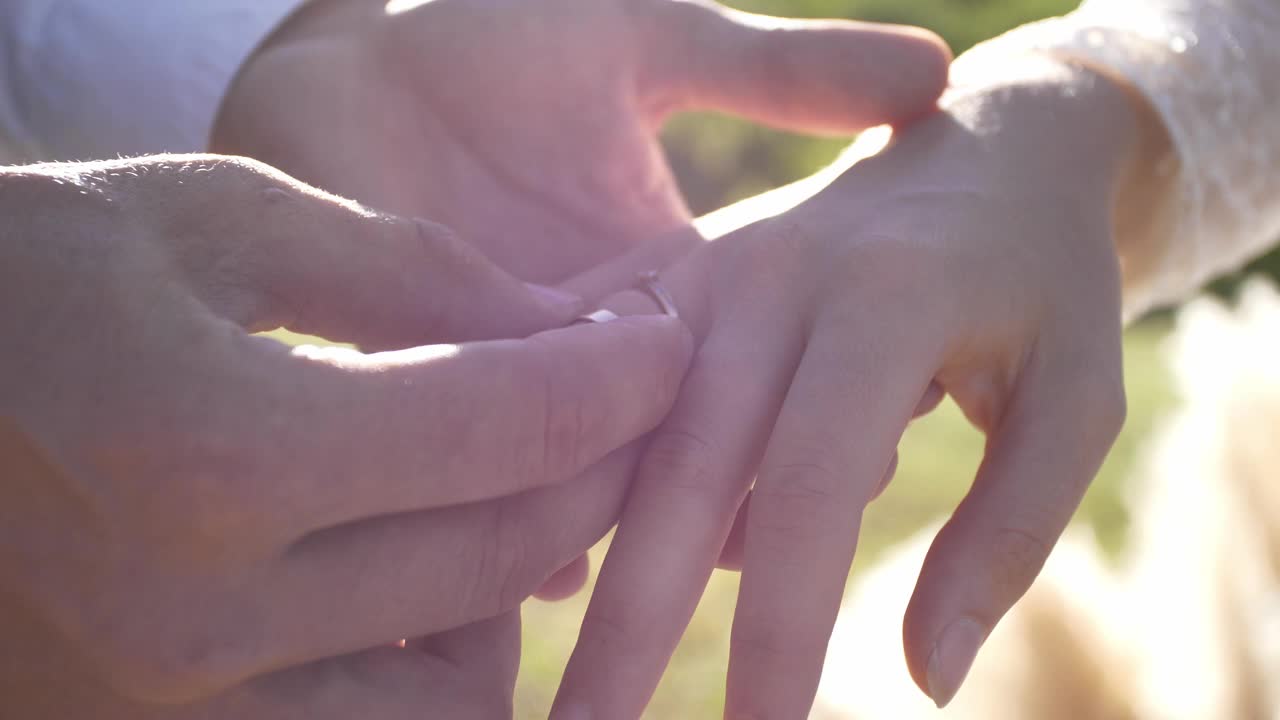 接触的概念。男人的手把结婚戒指戴在女人的手上。视频素材