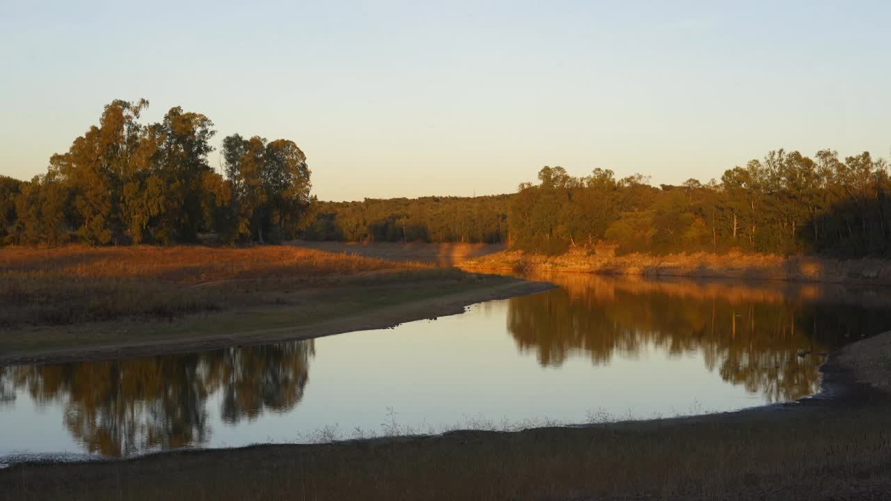 西班牙Olivenza附近的Embalse de Piedra Aguda湖大坝，在夕阳下的水面上有美丽的倒影视频素材