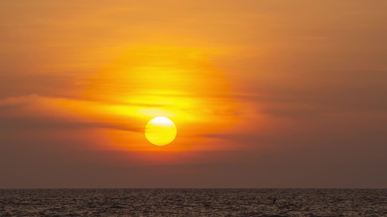 海外金色日落的时间流逝。在夏天的傍晚，圆形的橙色的太阳落入水中。景观自然日出背景。镜头b一卷太阳。黄色的日落的天空。美丽平静的海洋。视频素材