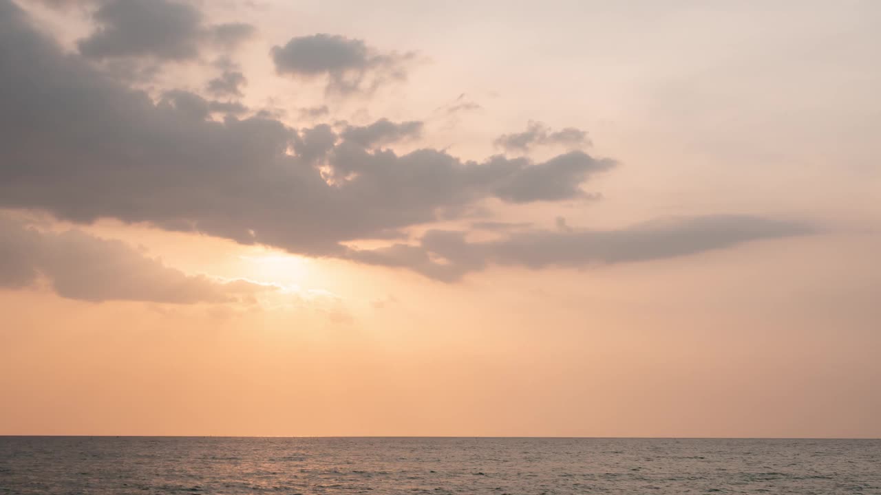 时间流逝的日落天空，橙色柔和的傍晚在夏季炎热的天气。乌云遮住了太阳。阳光穿过乌云。海面上的日落。旅行热带海滩和海洋视频素材