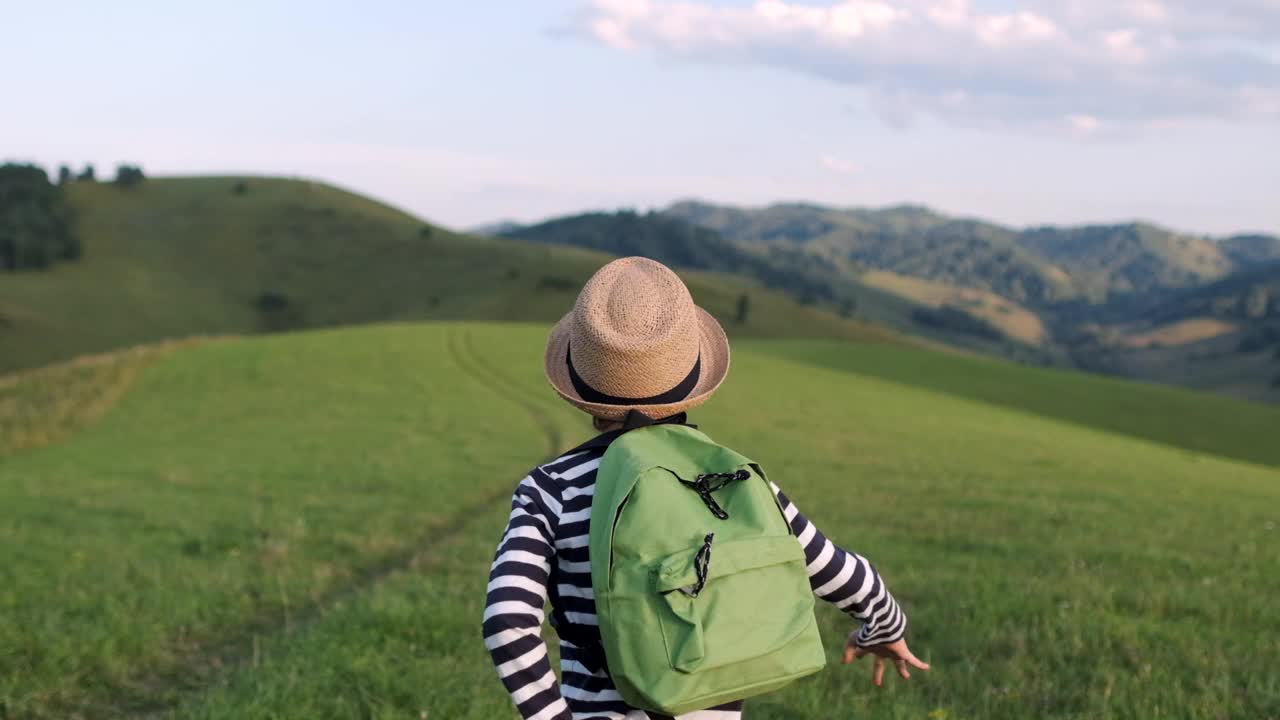 小男孩小孩年轻的徒步旅行者背包跑在山上旅行视频素材