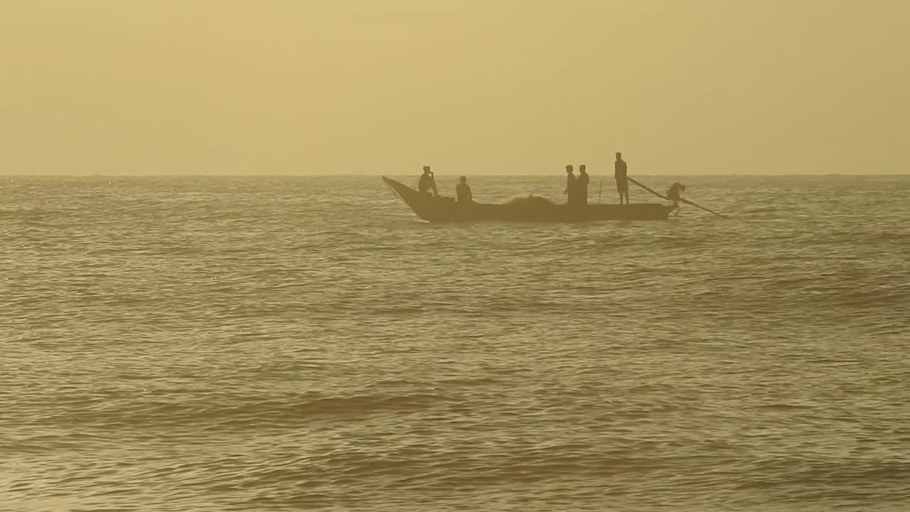 早上，人们在海洋中乘木筏钓鱼。海浪翻滚翻滚，波浪起伏，美丽的沙滩细密而清澈的海水和岸边的天空。视频素材